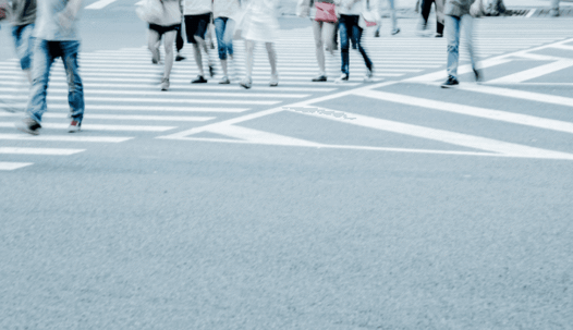 people walking across an urban crosswalk.