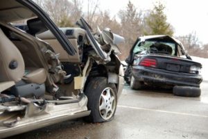 Two cars are involved in a collision at an intersection, with visible damage to their front ends.