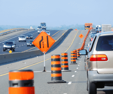 The image captures a view along a highway or bridge on a bright, sunny day