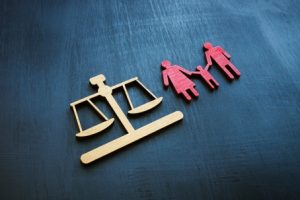 A balance scale and a family cutout symbolize themes of justice and family law.