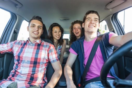 Four individuals are seated in a car.