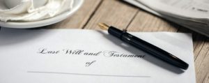 A document titled "Last Will and Testament" is displayed with a blank space for the name, accompanied by a black fountain pen placed on the document.