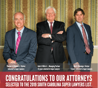 Three men in formal business attire are standing in front of a patterned wallpaper. Below them, text highlights their professional achievements, congratulating them for their selection to the 2019 South Carolina Super Lawyers list.